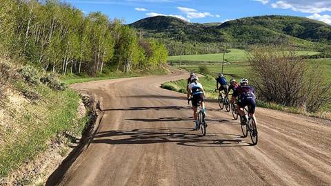 A group of bike riders on a dirt road.