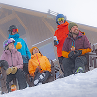 A group of friends enjoying apres outside of Four Points Lodge.