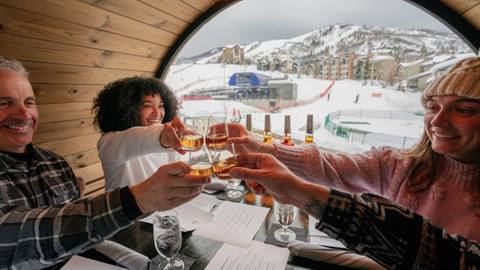 A group of friends enjoying a whiskey tasting inside a Stranhans whiskey barrel at Steamboat Resort.