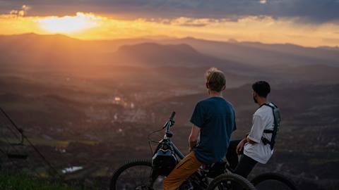 Two mountain bikers overlooking the sunset over the Yampa Valley.