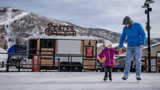 A father and daughter ice skating at Steamboat Resort.