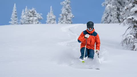 male skier going down a powder ski run